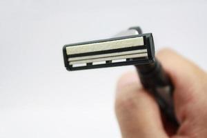 Hand with shaving razor isolated on a white background photo