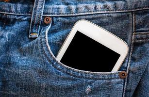 teléfono móvil en el bolsillo de los jeans con pantalla negra foto