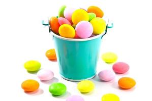 Bucket of colorful candy on white background photo