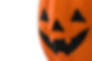 Blurred Halloween Jack O Lantern face over white background photo