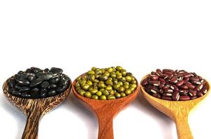 Legumes in a wooden spoon placed on a white background photo