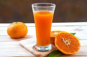 Cold orange juice on wooden table photo