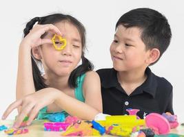 enfoque selectivo de niños asiáticos felices jugando juguetes de arcilla coloridos foto