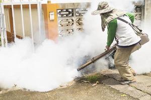 Man is using thermal fog machine to protect mosquito spreading photo