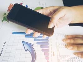 Vintage style photo of a lady is using mobile telephone with her business report document