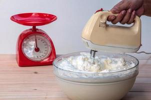 Hacer pastel de crema de mantequilla con batidora de mano foto