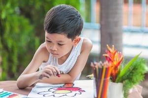 el niño está pintando un cuadro colorido en casa. la foto se centra en sus ojos.