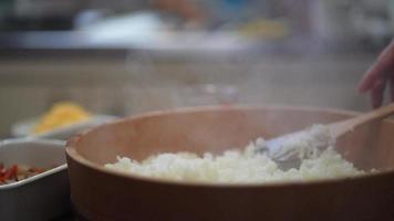mãos femininas misturando arroz avinagrado