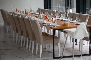 Festive romantic table setting with silverware, gray napkin and white crockery on beige silk tablecloth photo