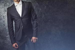 Man in suit against concrete wall photo