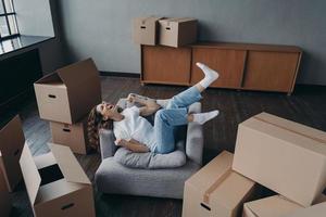 Una joven española llena de alegría ha comprado un apartamento nuevo. la dama se relaja en el sillón. foto