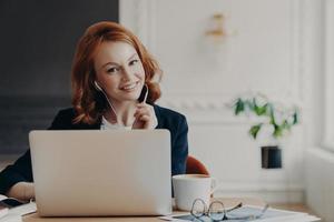 University student studies online from home, discusses project work with professor, poses in coworking space and drinks aromatic coffee. Video conference, vitrual event, online education concept photo