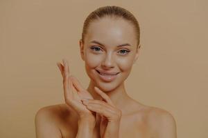 hermosa mujer tocando manos suaves y suaves para bebés después de los procedimientos de spa, aislada en un fondo pastel foto