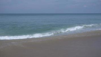 turquoise golven gerold op het strandzand, mai khao beach, phuket, slow motion video