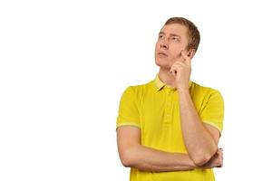 Thoughtful guy in yellow T-shirt looking to left, white background, philosophical reflection photo