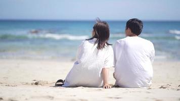 una coppia seduta sulla spiaggia e parlando video