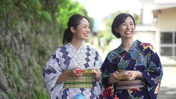 mulher yukata andando com ioiô e yakisoba video