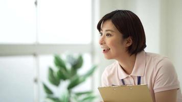 Image of a caregiver holding a binder and asking questions video