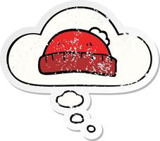 cartoon woolly hat and thought bubble as a distressed worn sticker vector
