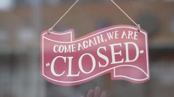 A woman turning over the shop sign video