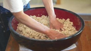 uomini che aggiungono acqua alla farina di grano saraceno e mescolano video