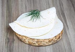 tortillas en plato de madera y fondo de madera foto