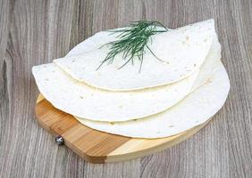 tortillas en plato de madera y fondo de madera foto