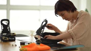 A woman grooming a snowboard board video