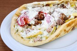 Souvlaki on the plate and wooden background photo