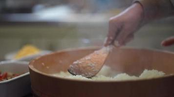 manos de mujer mezclando arroz con vinagre video