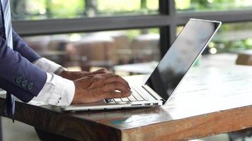 Businessman in a hurry using a laptop computer at a cafe video