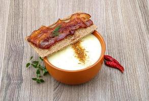 Cheese soup in a bowl on wooden background photo