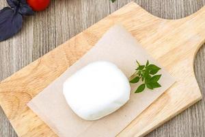 Mozzarella on wooden plate and wooden background photo