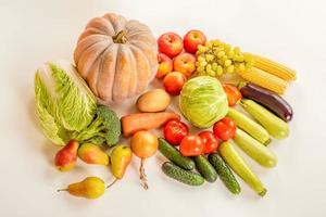 cosecha. una variedad de verduras y frutas sobre un fondo blanco. foto