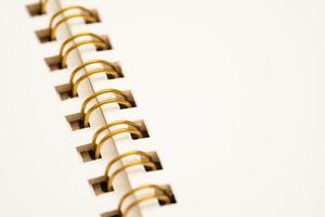 primer plano del libro de trabajo. cuaderno espiral en blanco aislado. cuaderno con espiral dorada. foto