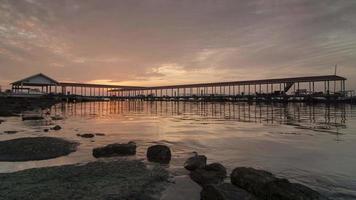 timelapse sorgere del sole e nuvole in movimento al molo del pescatore. video