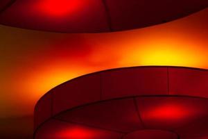 Interior ceiling red lights on dark background at night. Interior lighting concept. Red lights on ceiling. Architecture abstract background photo