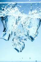 Abstract background image of ice cubes in blue water.