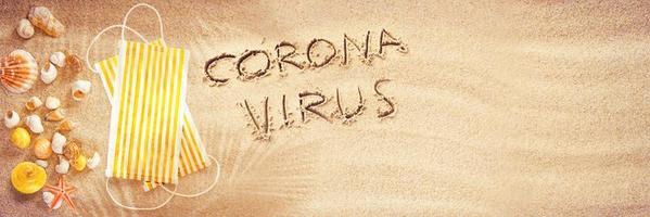 corona virus escrito en la arena de vacaciones foto