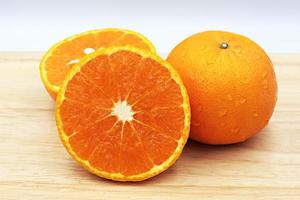 fruta naranja fresca con gotas aisladas sobre fondo blanco. foto