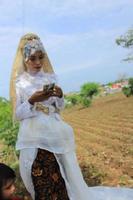 enfoque selectivo de las mujeres que llevan un vestido de novia típico de java, indonesia foto