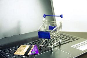 Computer notebook blank screen with shopping cart on wood table photo