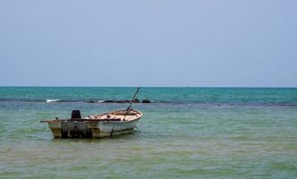 landscape look view Small fishing boat wooden old parked coast the sea. after fishing of fishermen in small village It small local fishery. Blue sky, white clouds, clear weather, Phala Beach, Rayong photo