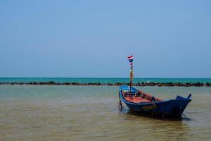 paisaje mirada vista pequeño barco de pesca de madera antiguo estacionado costa el mar. después de la pesca de los pescadores en el pequeño pueblo es pequeña pesca local. cielo azul, nubes blancas, clima despejado, playa phala, rayong foto