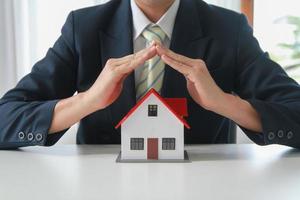 Accountant, businessman, real estate agent, business woman handing model house to customers along with house interest calculation documents for customers to sign. photo