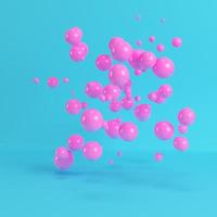 Pink flying spheres on bright blue background in pastel colors photo