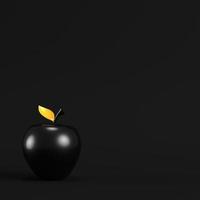 Black apple with golden leaf on dark background. Minimalism concept. photo