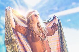 Woman with long curly hair plays with a veil in the nature photo