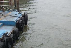 los neumáticos están unidos a cadenas para amortiguar el borde del muelle. foto