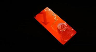 Bitcoin crypto currency in smartphone. Red market. photo